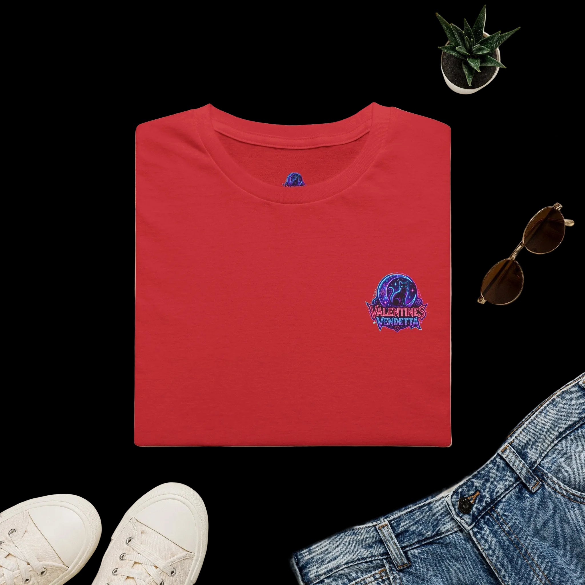 Red t-shirt with a 'USA' design on a light surface with a hat, sunglasses, and jeans.